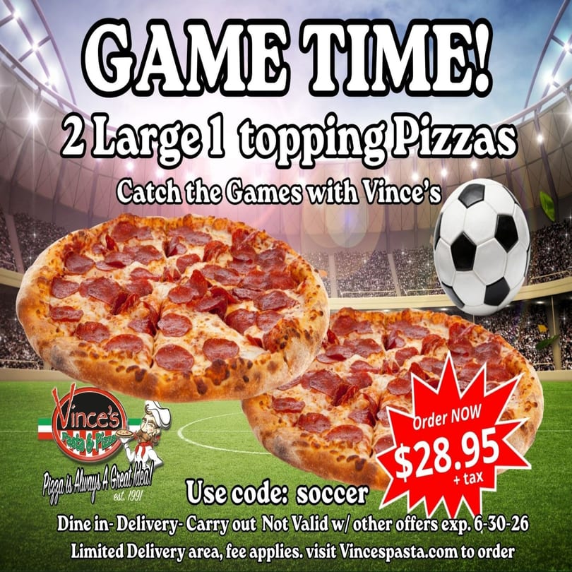 Two large pepperoni pizzas on a soccer field with a soccer ball and stadium lights in the background.